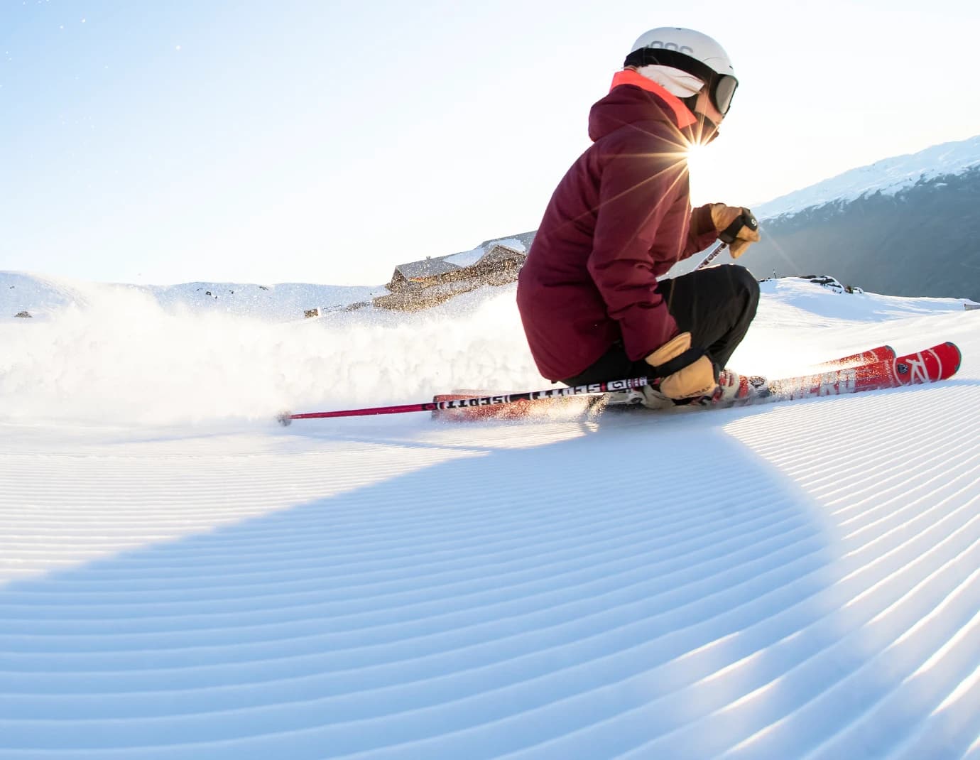 A skier carves on fresh cord on a bluebird day.