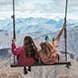 Two people swinging on a chair at Cardrona Alpine Resort.