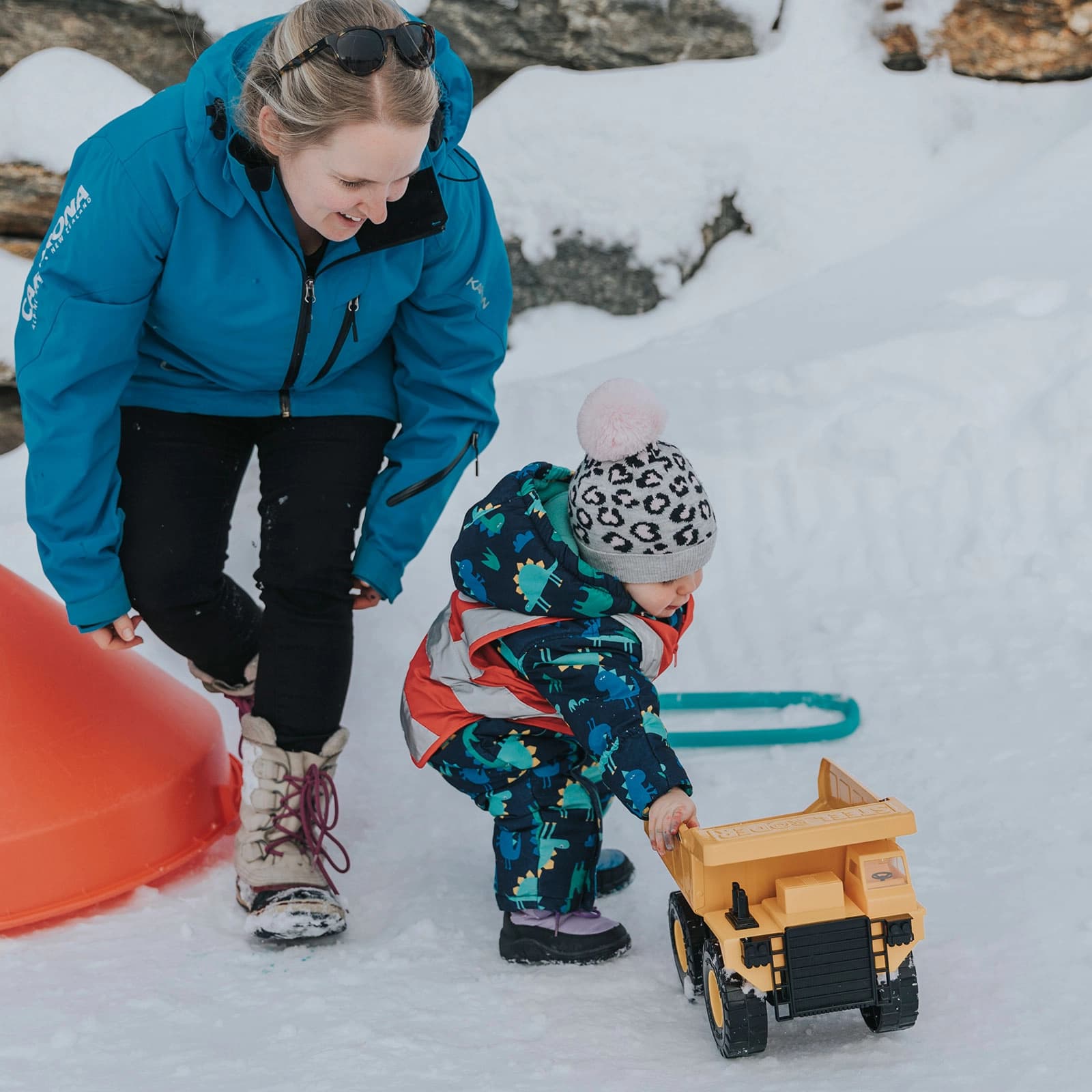 A staff member at the Cardrona childcare centre plays with a child in the snow.