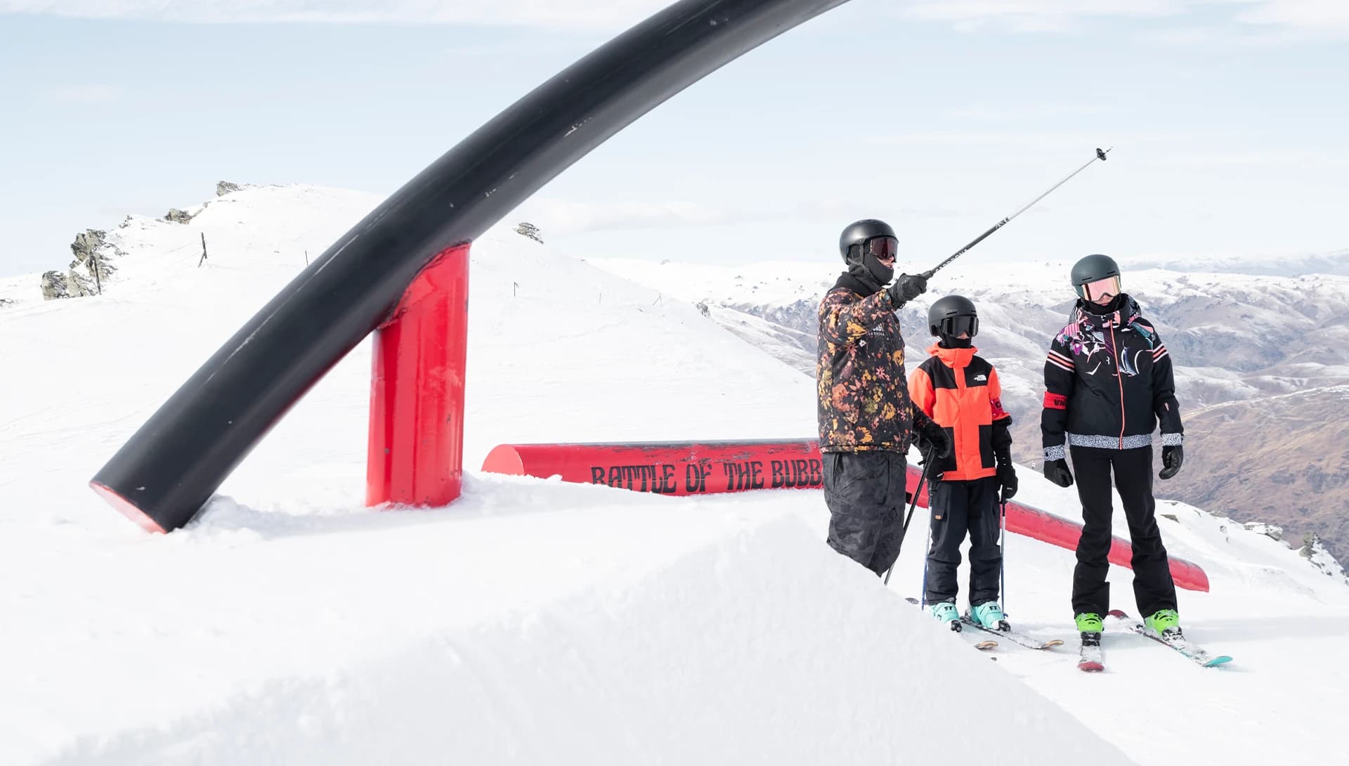 An instructor at Cardrona Alpine Resort points out features in the terrain park to young skiers, helping them prepare for an event.