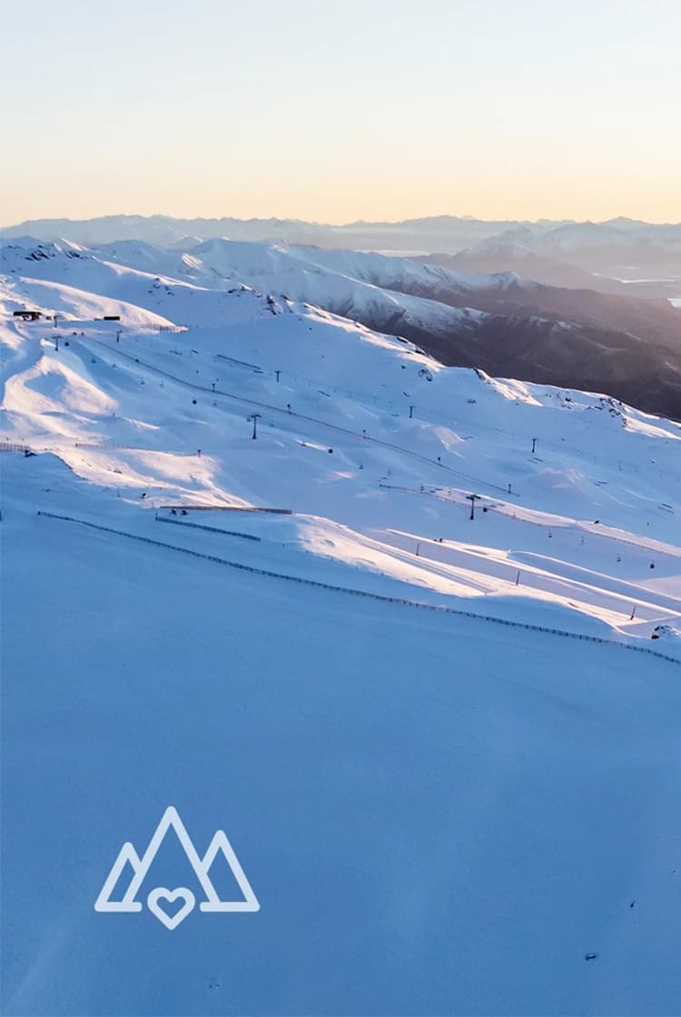 An aerial view of Cardrona Alpine Resort at sunrise. Showcases base and park from above.