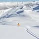 A lone skier in a yellow jacket heads in to the Soho Basin.