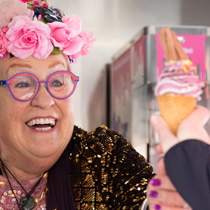 The famous Carol from Carol's ice cream shop gives a colourful ice cream to a customer.