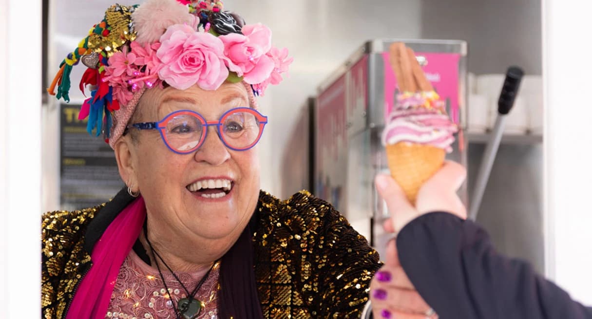 The famous Carol from Carol's ice cream shop gives a colourful ice cream to a customer.