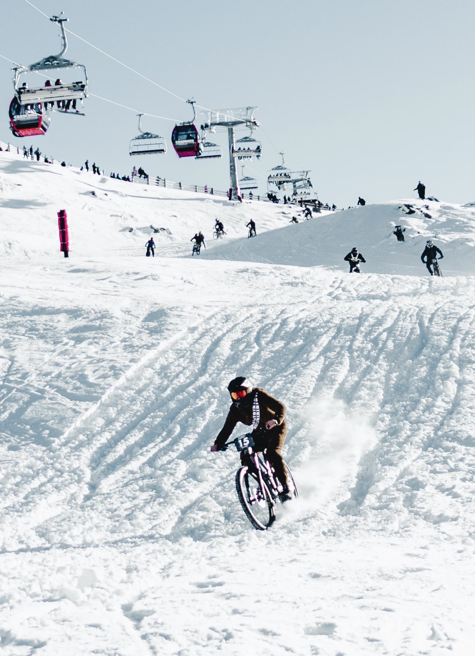 Ski field event where people mountain bike down snowy tracks.