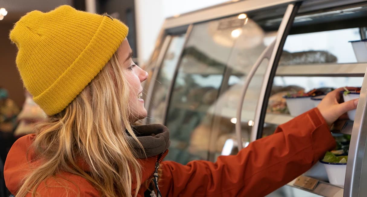 A lady selects food from a range of cabinet at Cardrona.